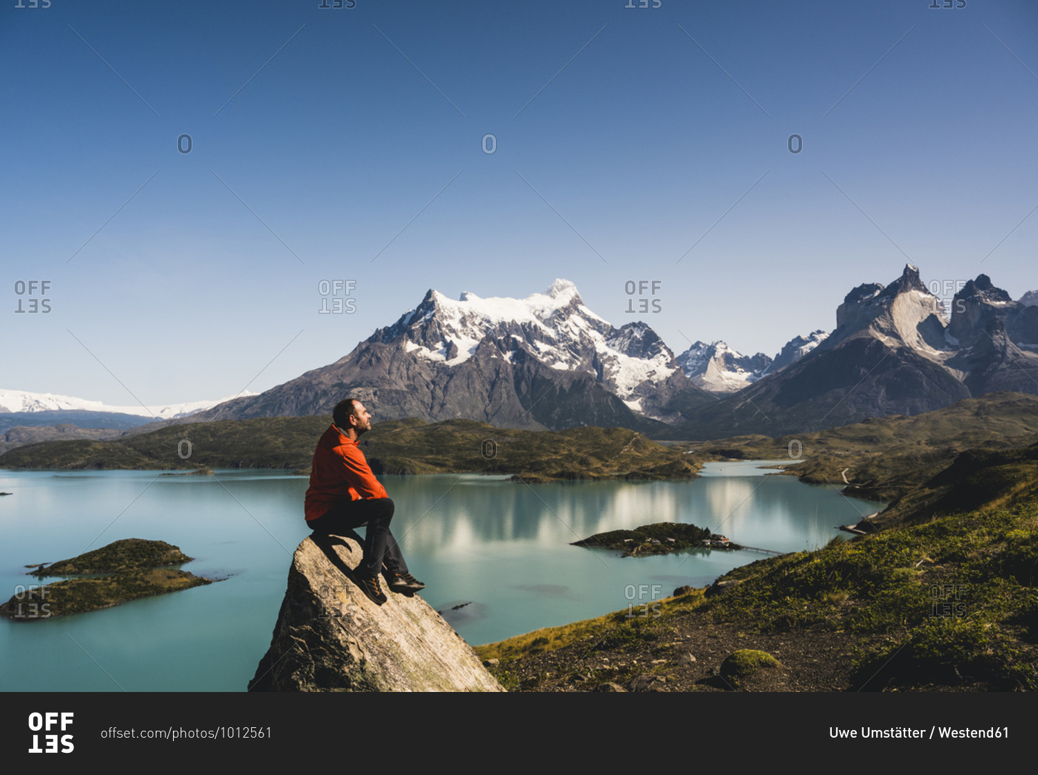 Man sitting on rock at Lake Pehoe in Torres Del Paine National Park- Chile Patagonia- South America