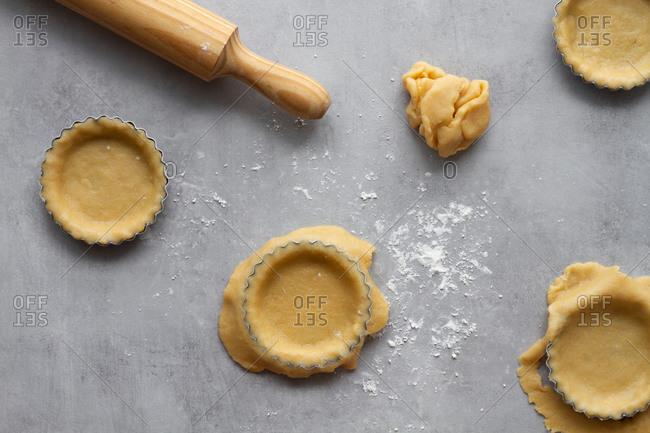 Top view of homemade short crust dough for lemon pie arranged in metal baking molds