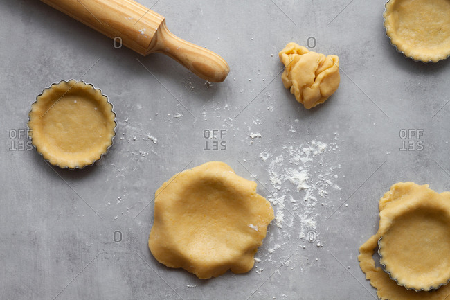 Top view of homemade short crust dough for lemon pie arranged in metal baking molds