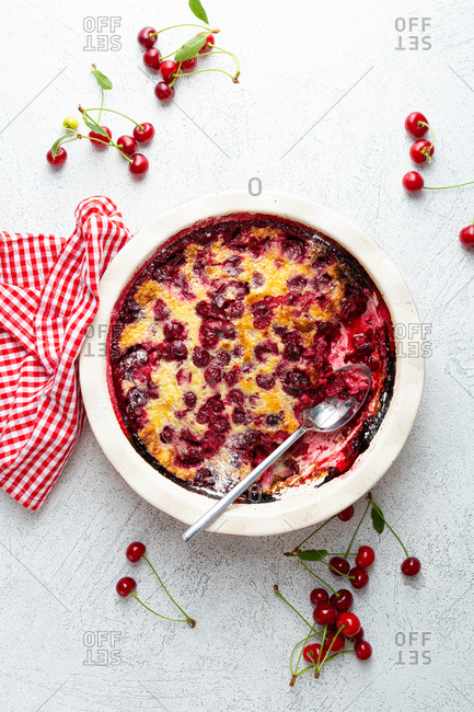 Cherry clafoutis and cherries on light surface