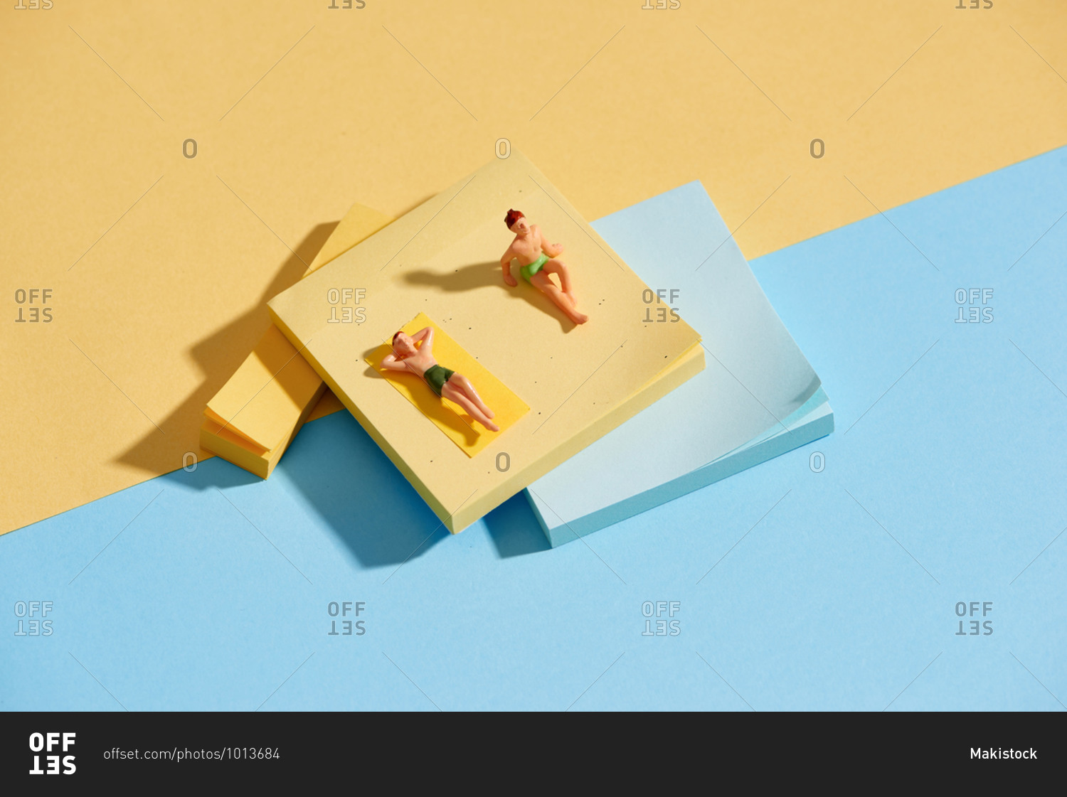 Miniature men sunbathing and relaxing on beach vacation concept