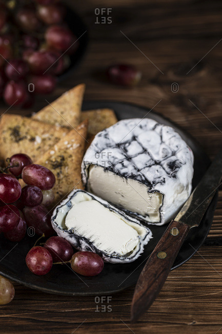 Ashed Brie served with crackers and brie on a wooden background.