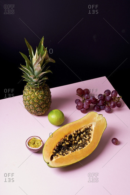 Tropical fruits still life with mango, papaya, pitahaya, passion fruit, grapes, lime and pineapple. Fruit plate
