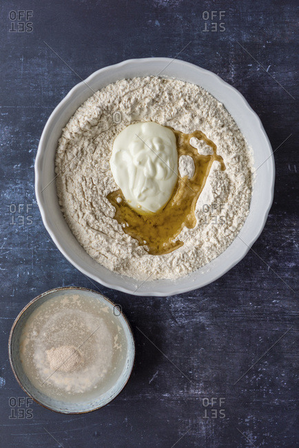 Flour, yogurt and olive oil in a large bowl. Yeast, sugar and water in a small bowl on the side.