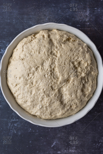 Turkish flatbread dough after first rise in a large bowl on a dark background