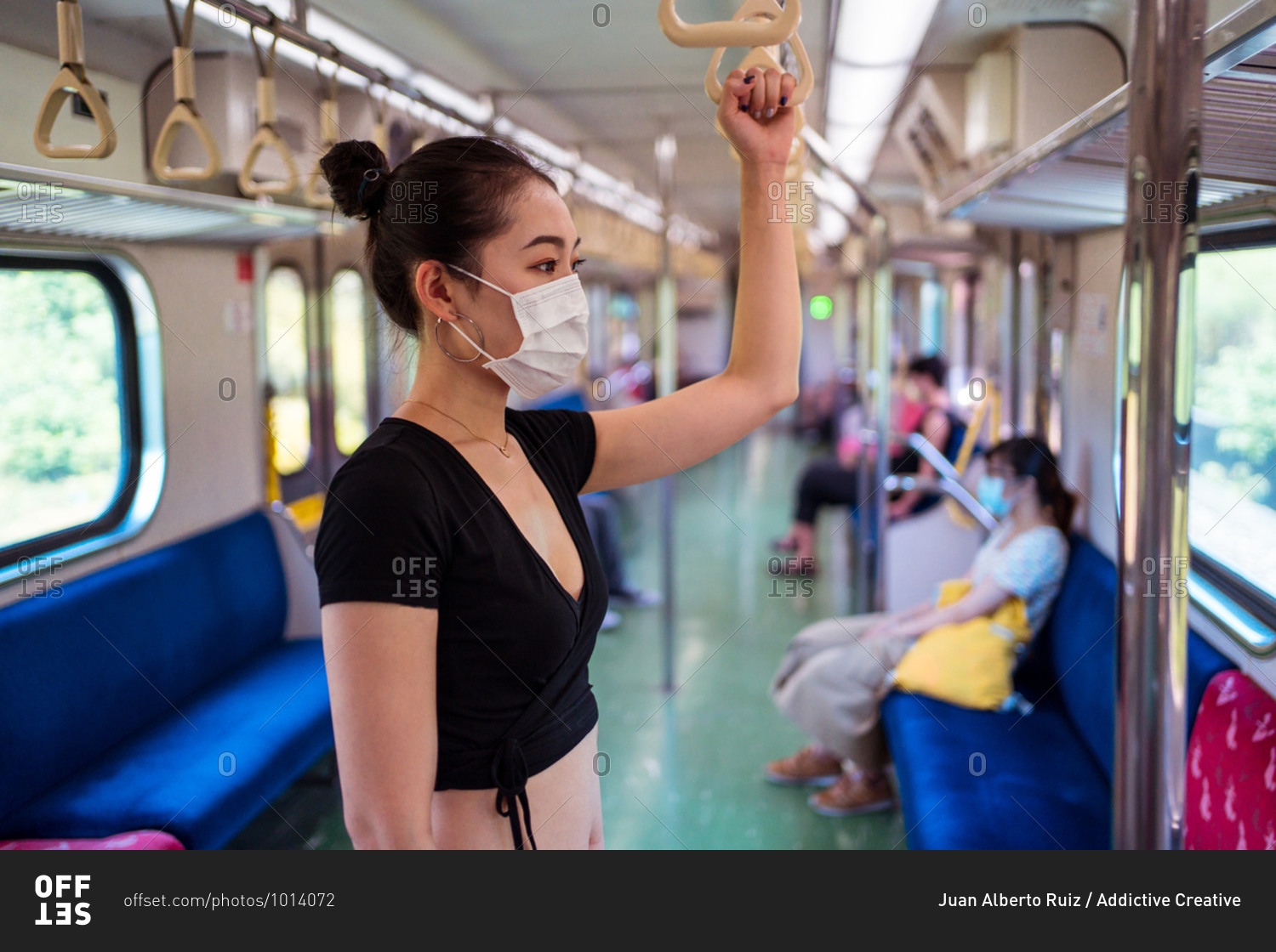 Side view of ethnic female wearing protective mask traveling by train during coronavirus outbreak