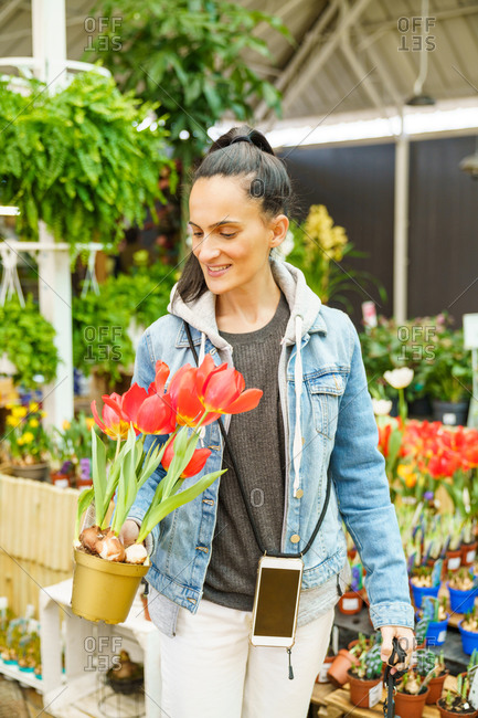 Young girl buying flowers and seasonal plants at a nursery