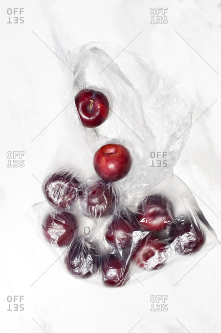 Top view of delicious ripe red cherry berries in transparent plastic sack placed on white table