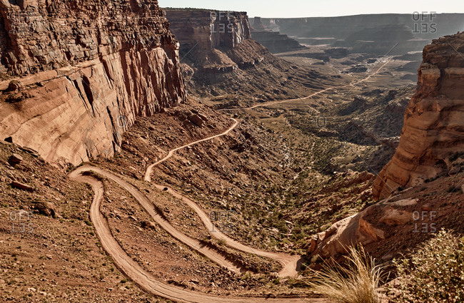 Majestic scenery of sandy road surrounded by rough mountains in Canyonlands National Park in Utah on sunny day