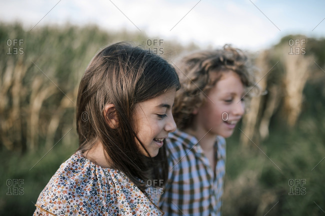 Girl and boy walking in a corn field