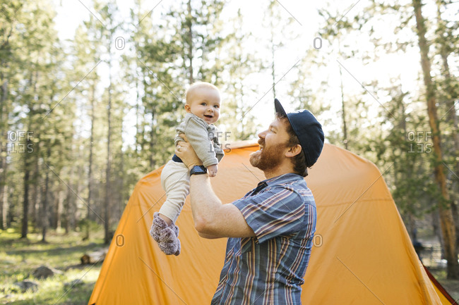 Father lifting baby boy(6-11 months) by tent in Uinta-Wasatch-Cache National Forest