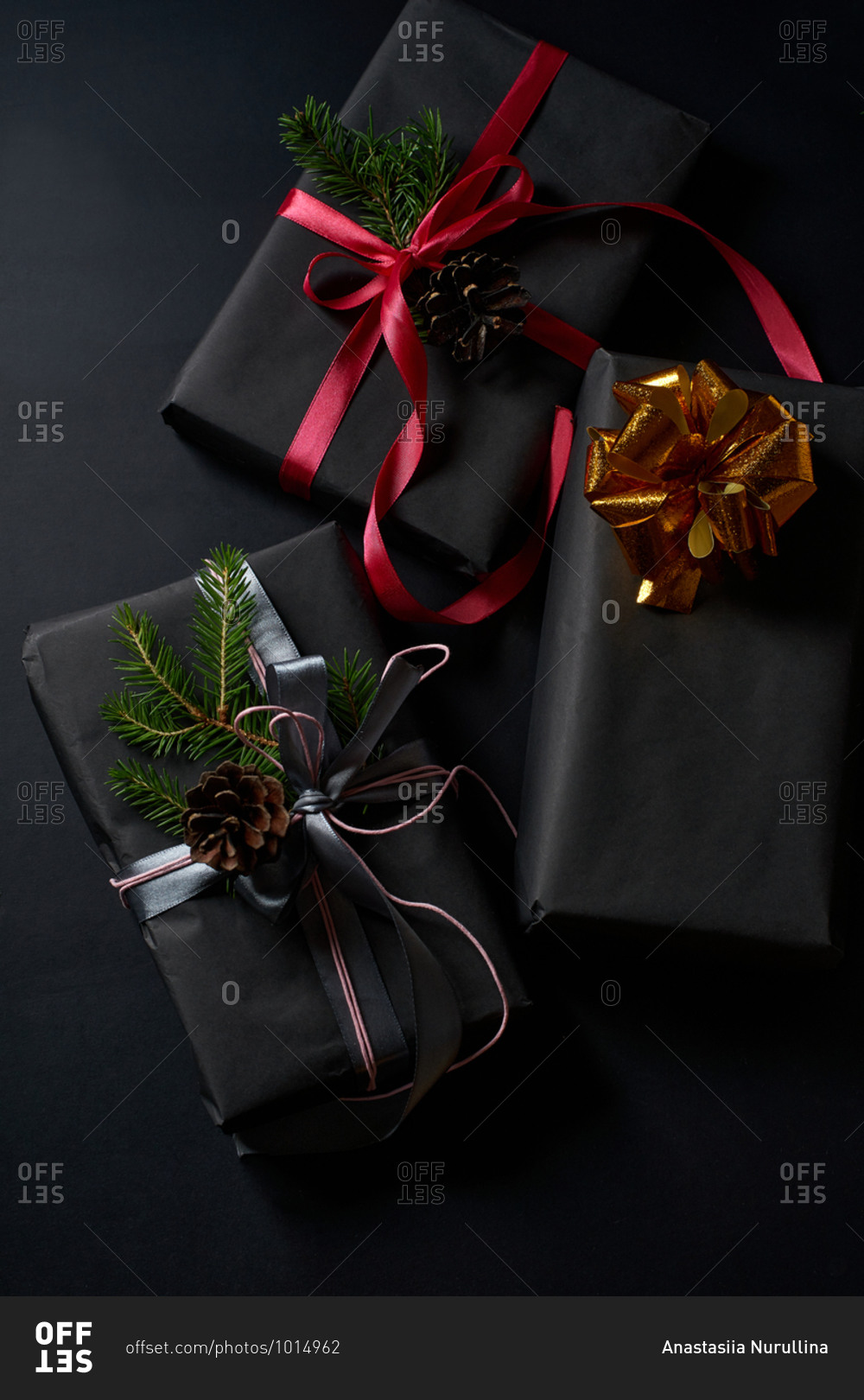 Wrapped and decorated gifts and boxes with presents on black background viewed from above
