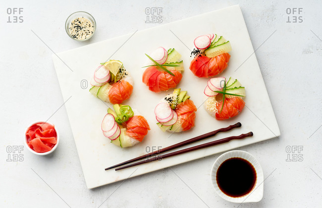 Sushi donuts with salmon and veggies on marble cutting board