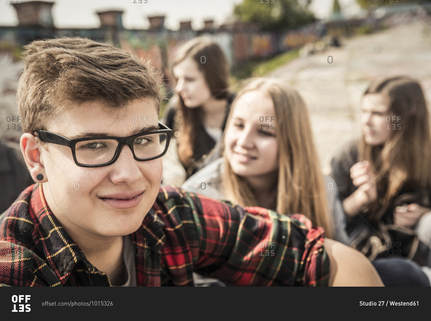 Portrait of smiling teenage hanging out with friends in an old run down industrial area