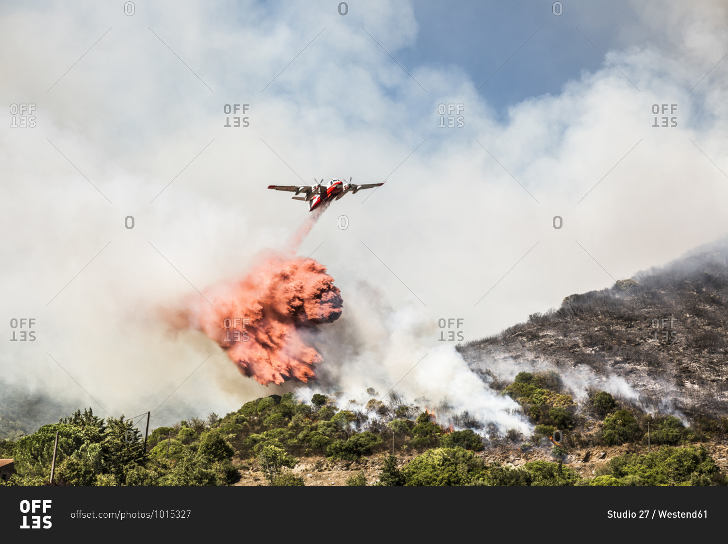 Aerial fire fighting aircraft dropping load of flame retardant on wildfire- Corsica- France