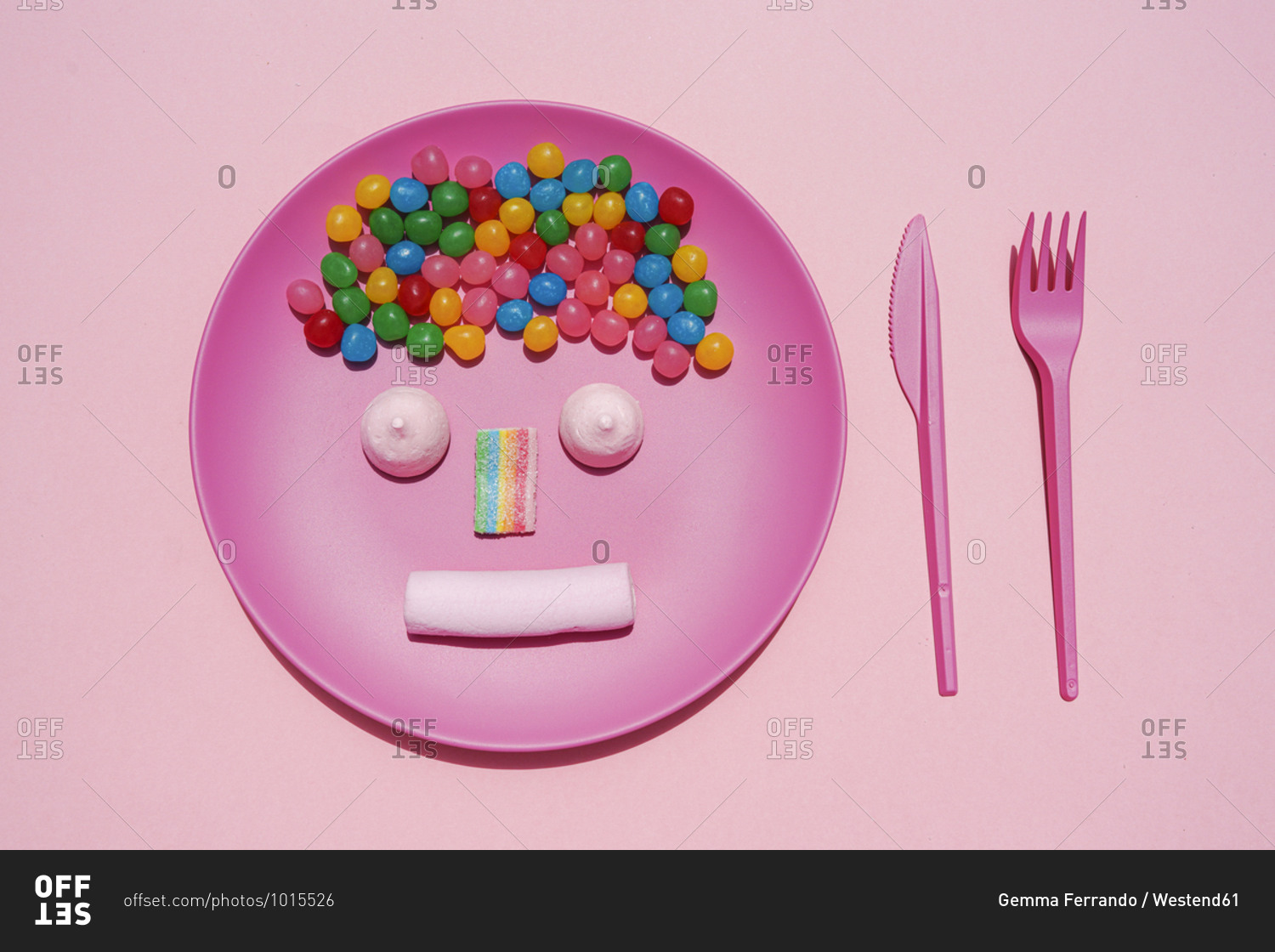 Studio shot of plastic plate with colorful candies and anthropomorphic face made of marshmallows and gum drop