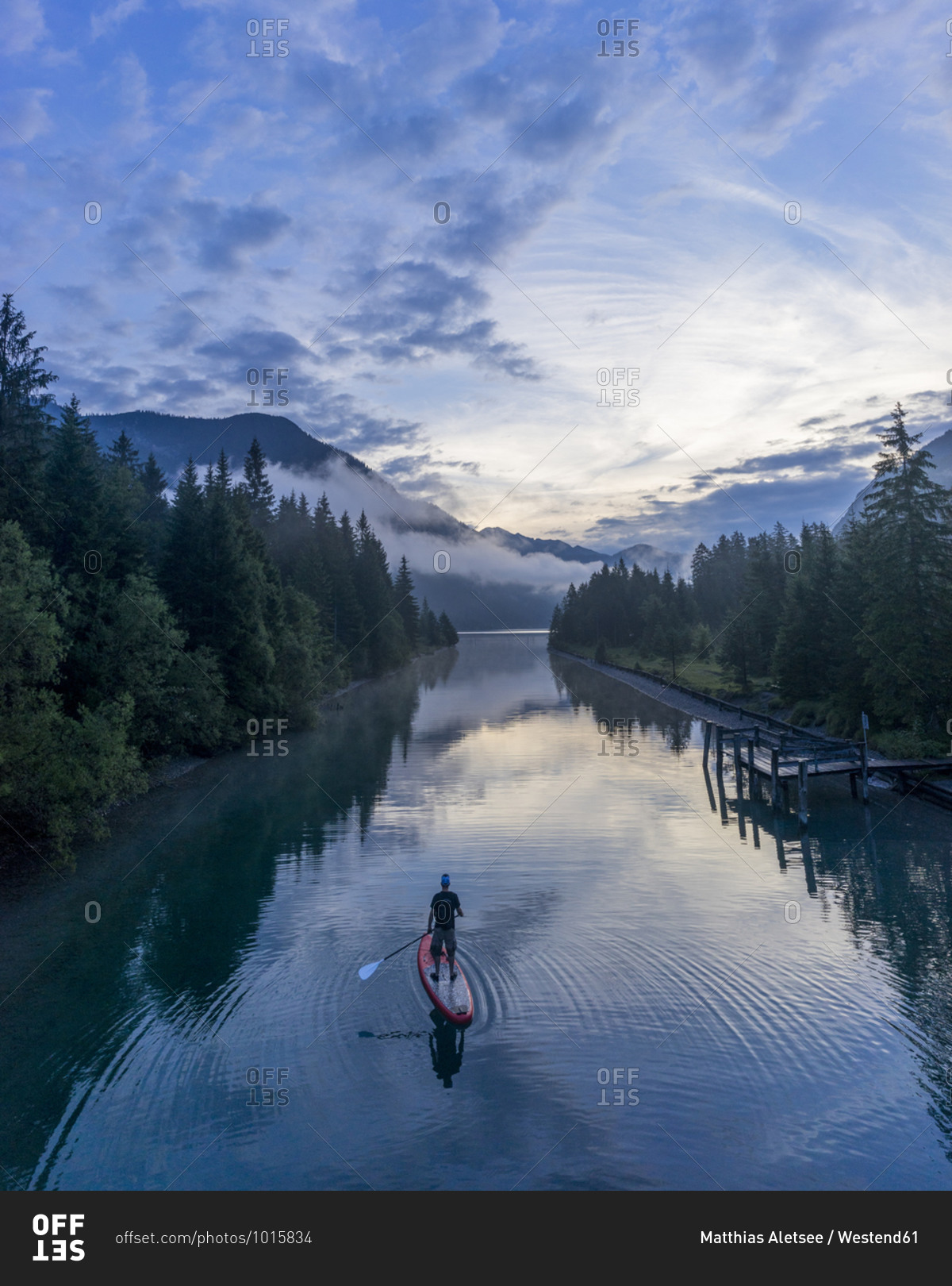Man on sup board on Lake Plansee in the evening- Tyrol- Austria