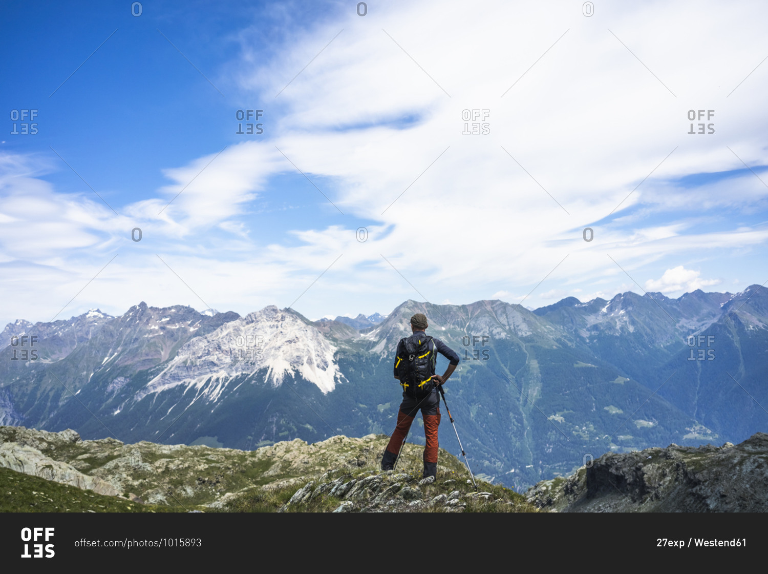 Hiker standing on top of peak while looking at mountains- Western Rhaetian Alps- Sondrio- Italy