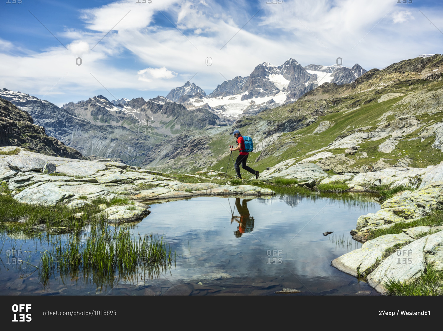 Man exploring while walking by lake at Western Rhaetian Alps- Sondrio- Italy
