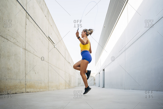 Young woman skipping rope outdoors