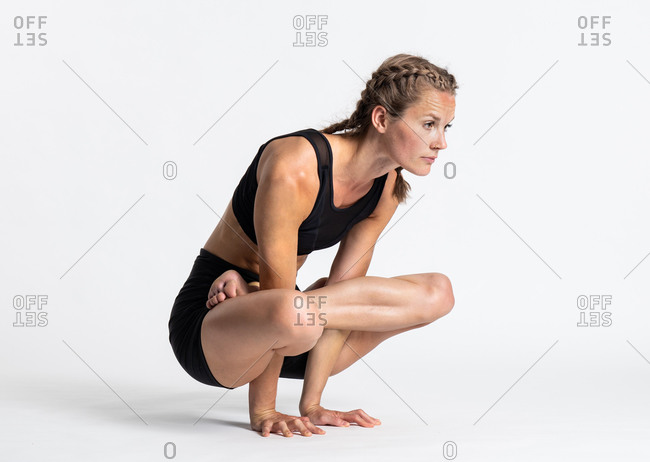 Back view of unrecognizable people performing Padmasana yoga pose on wooden  platform during outdoor training with female instructor in garden stock  photo