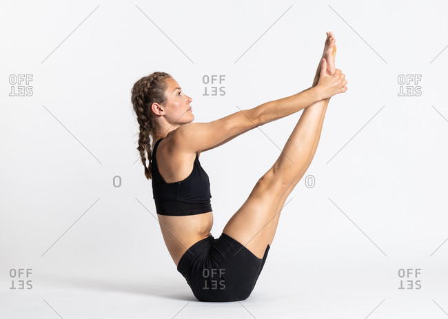 Premium Photo | Woman practicing yoga sitting in boat pose exercise  paripurna navasana workout wearing black sportswear full length