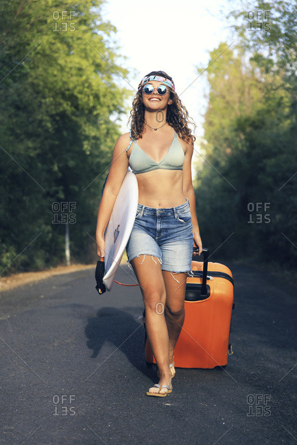 Girl with a suitcase. Young and Pretty Hippie on a Deserted Road