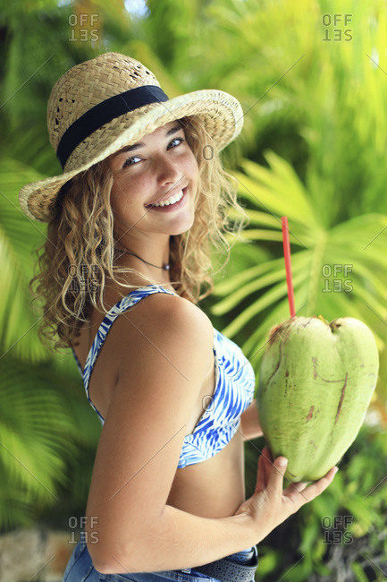 Portrait of an exotic girl drinking from a coconut