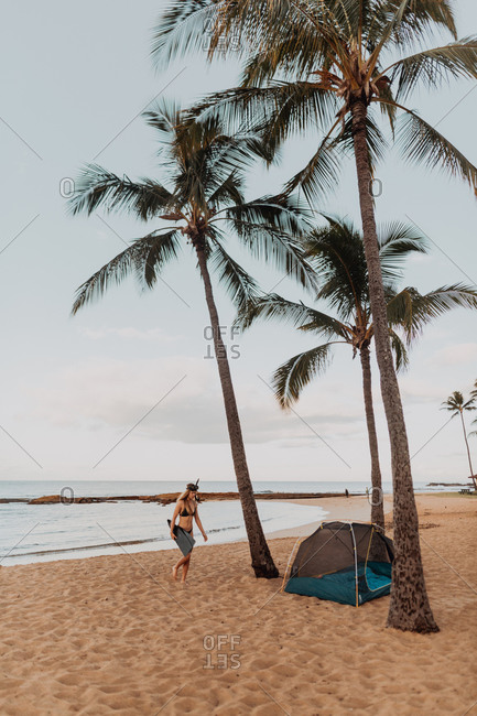 Scuba diver by tent on sandy beach, Princeville, Hawaii, US
