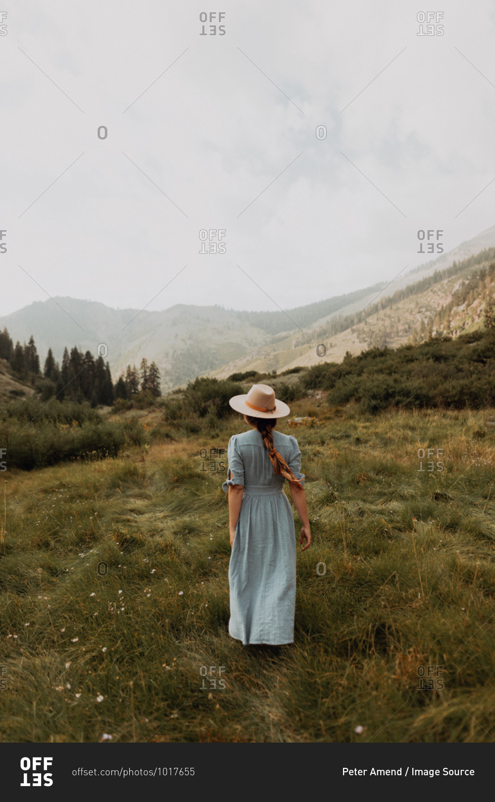 Young woman in stetson and maxi dress strolling in rural valley, rear view, Mineral King, California, USA