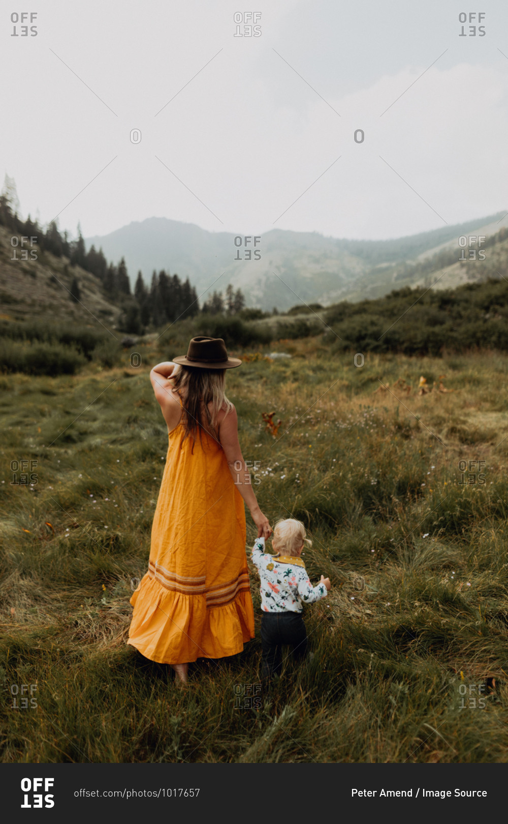 Mother holding toddler daughter\'s hand in rural valley, rear view, Mineral King, California, USA
