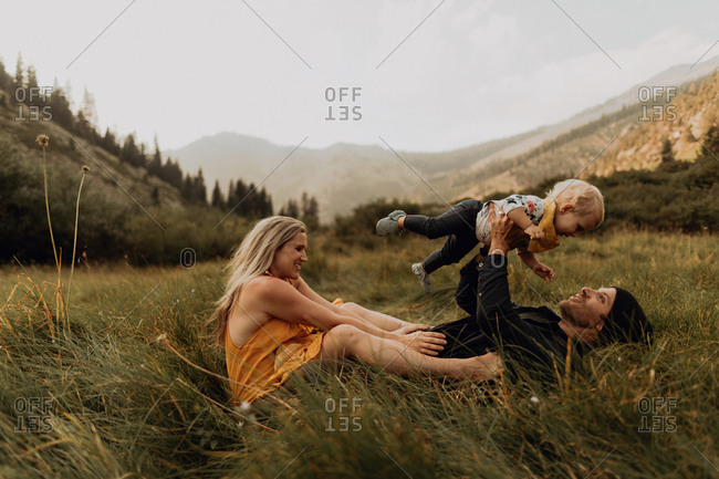 Mid adult couple holding up toddler daughter in rural valley, Mineral King, California, USA