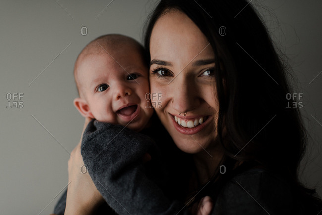 Young woman holding baby son, head and shoulder portrait