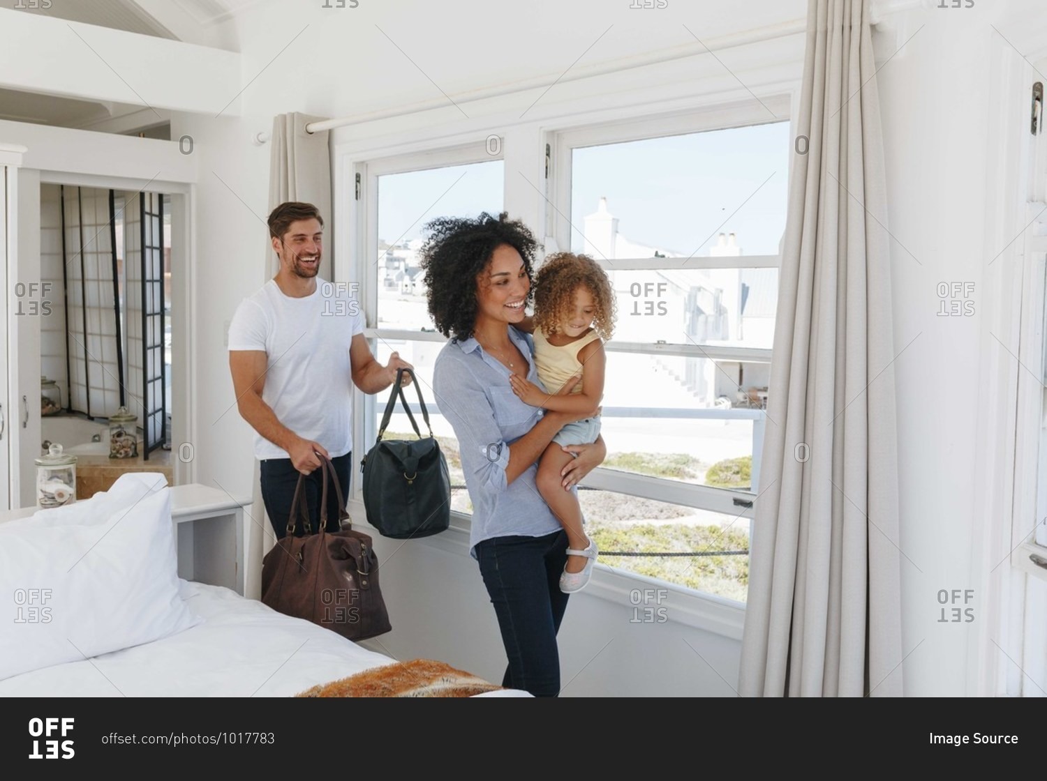 Couple and daughter leaving bedroom in beach house