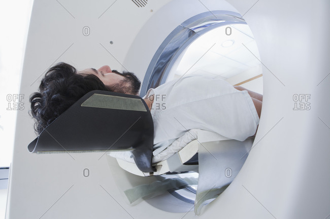 Young male patient having a CT scan in radiology department, low angle view