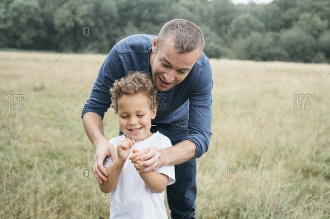 Happy father playing with his son in a field