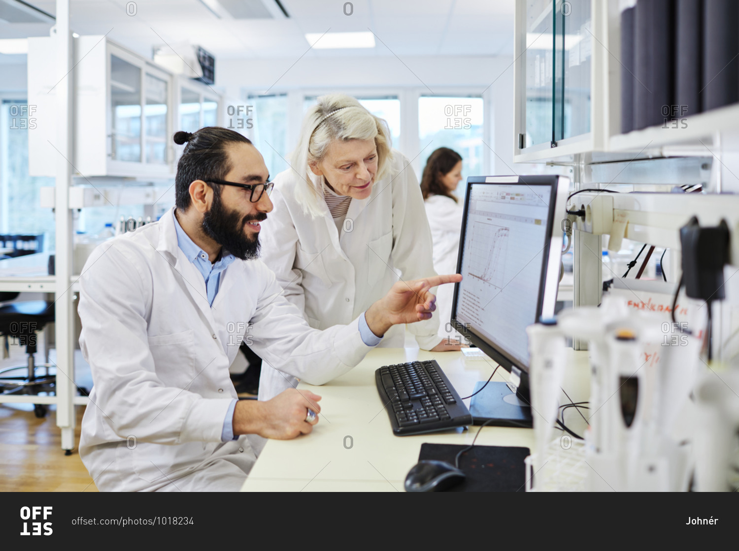 Scientists analyzing chart on computer screen