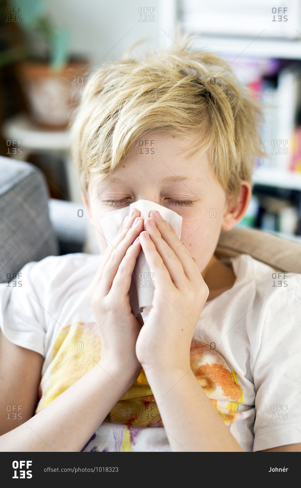 Boy with cold sneezing at home