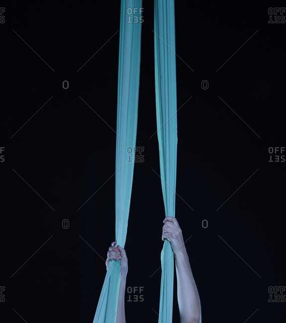 Two young female aerial acrobats practicing the splits on silk