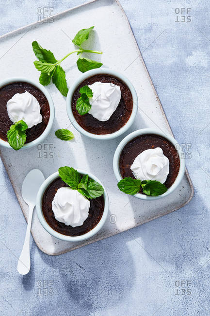 Overhead view of chocolate mousse dishes with whipped cream and mint