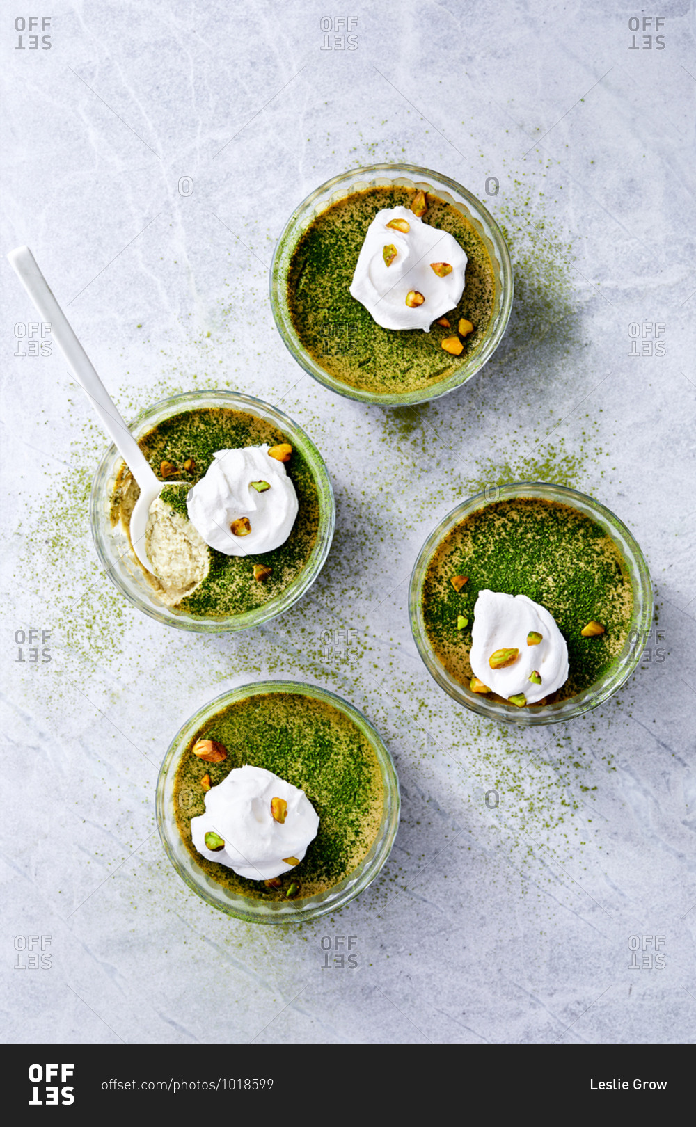 Overhead view of green tea coconut milk custard topped with whipped cream and pistachios