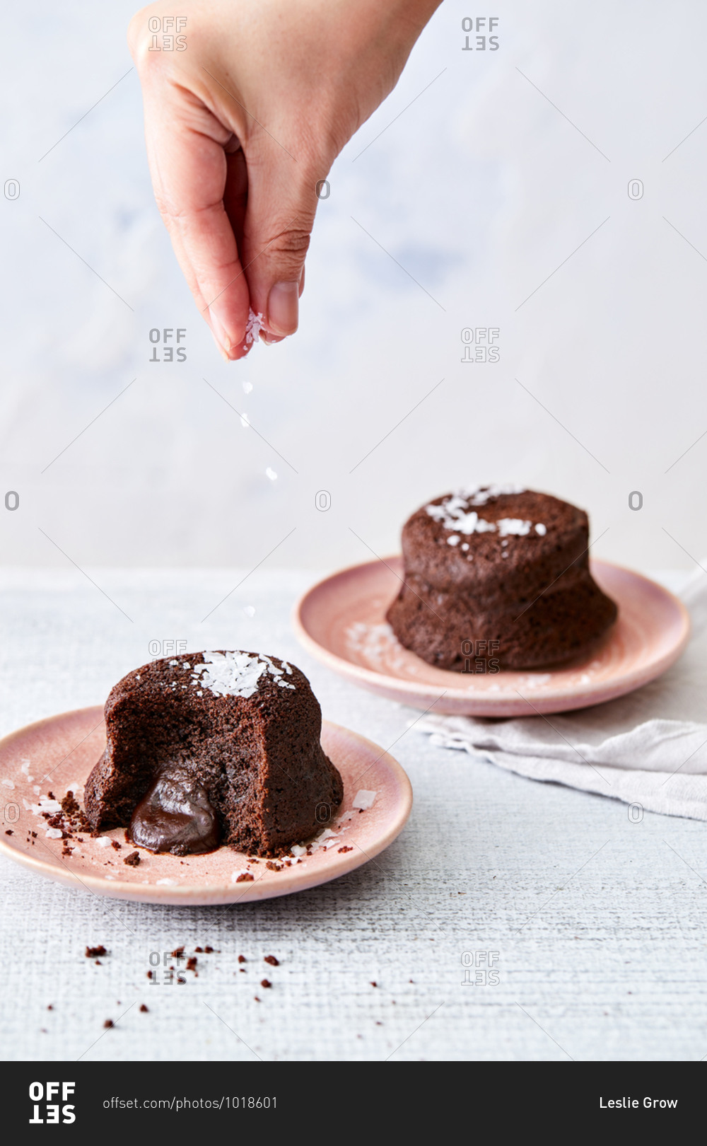 Hand sprinkling sea salt over chocolate lava cakes