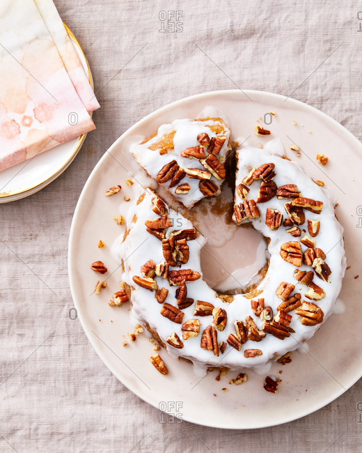 Overhead view of a lemon Bundt cake with icing and pecans