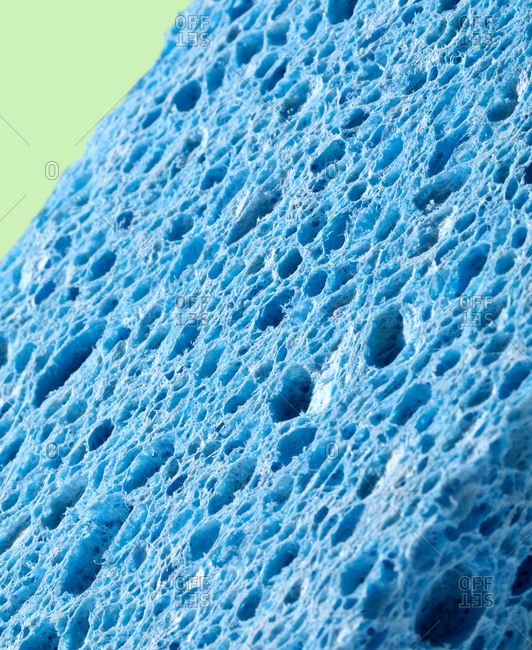 Close up of a blue sponge on light green background