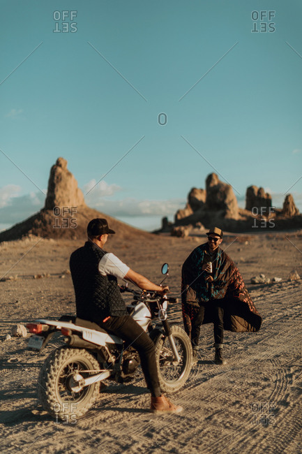 Motorcyclist friends talking on dirt track, Trona Pinnacles, California, US