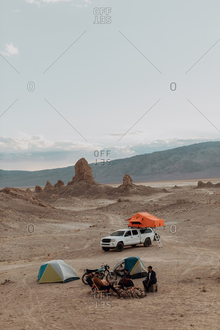 Motorcyclist road trippers around camp fire, Trona Pinnacles, California, US