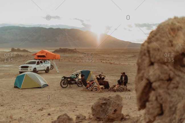 Motorcyclist road trippers around camp fire, Trona Pinnacles, California, US