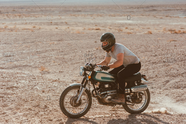 Motorcyclist riding in desert, Trona Pinnacles, California, US