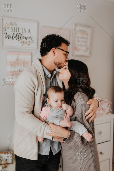 Couple with baby daughter in baby's room