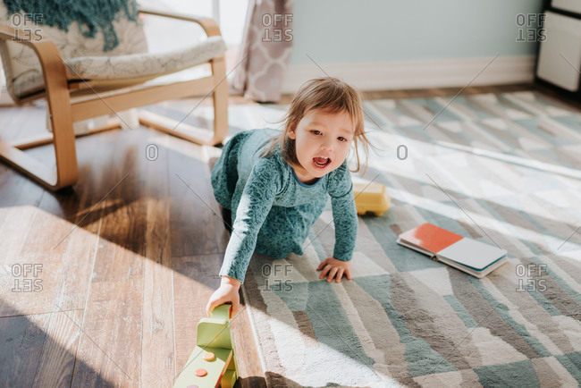 Female toddler playing on living room rug